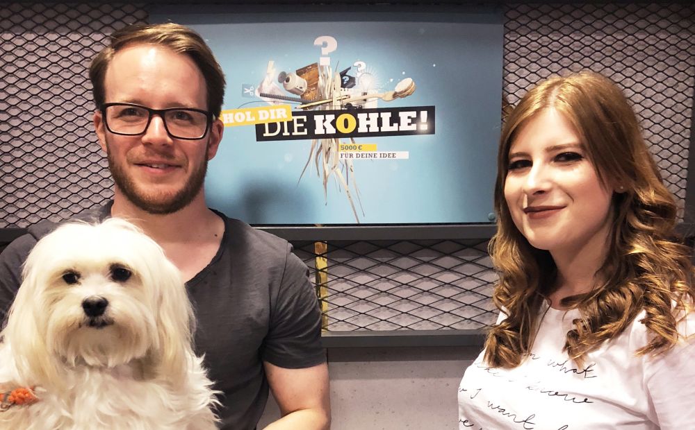 Werner, Anabel und Hund Lotti vor dem Hol-dir-die-Kohle Poster