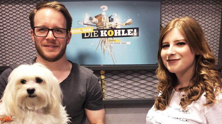 Werner, Anabel und Hund Lotti vor dem Hol-dir-die-Kohle Poster